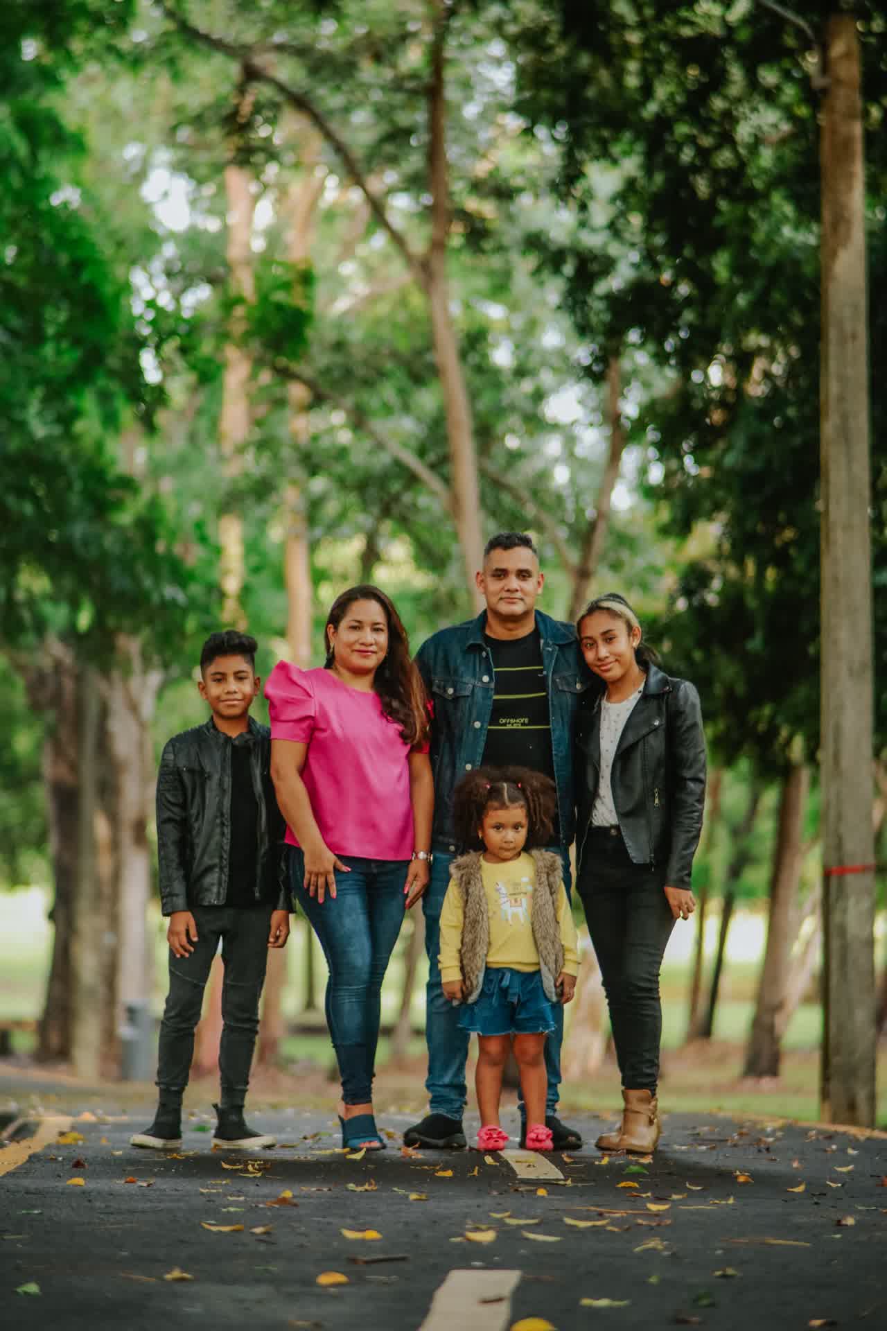 Familia latina de cinco integrantes reunida en un parque