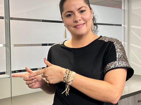 Yamiled señalando los testimonios en video de clientes de Inmigración USA TPS